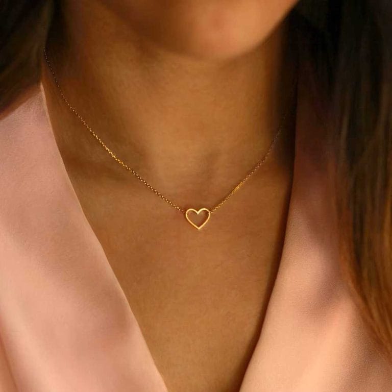 Collier coeur doré en acier inoxydable portée par une femme