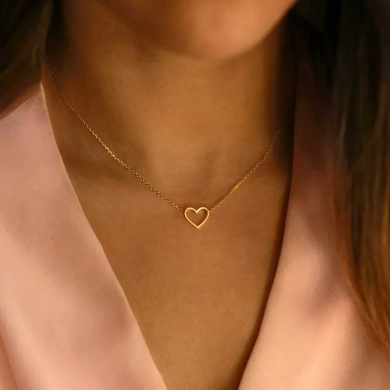 Collier coeur doré en acier inoxydable portée par une femme