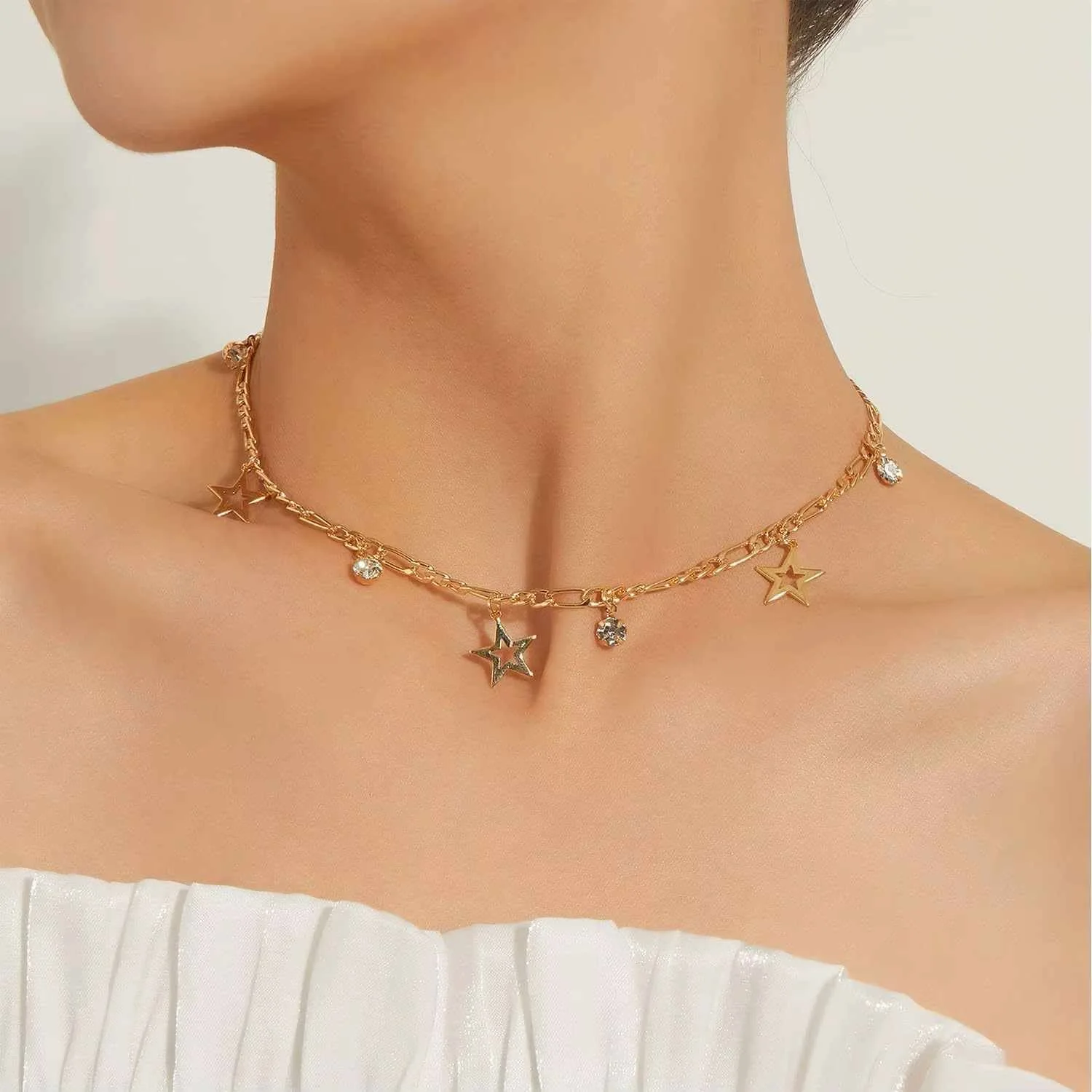 Collier Hilona avec étoile et diamant étoile en acier inoxydable doré porté par une femme